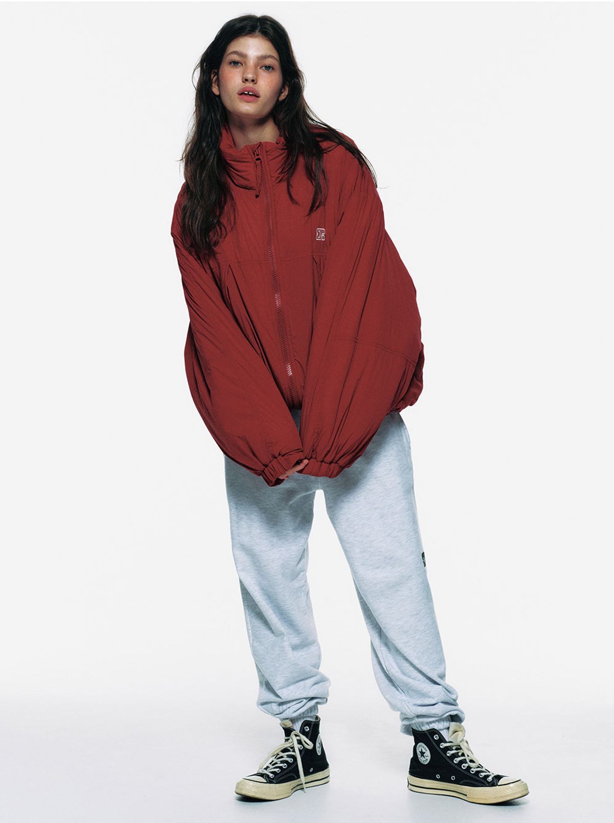 165cm 모델이 레드 패딩을 입고 야외에서 활동하는 전신 샷, 오버핏 실루엣과 엉덩이를 덮는 기장감이 강조된 모습