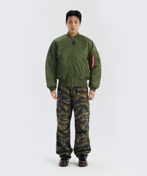 옷장 앞에 서서 여러 아우터를 대보며 고민하다가 알파 인더스트리 MA-1 자켓을 꺼내 드는 모습