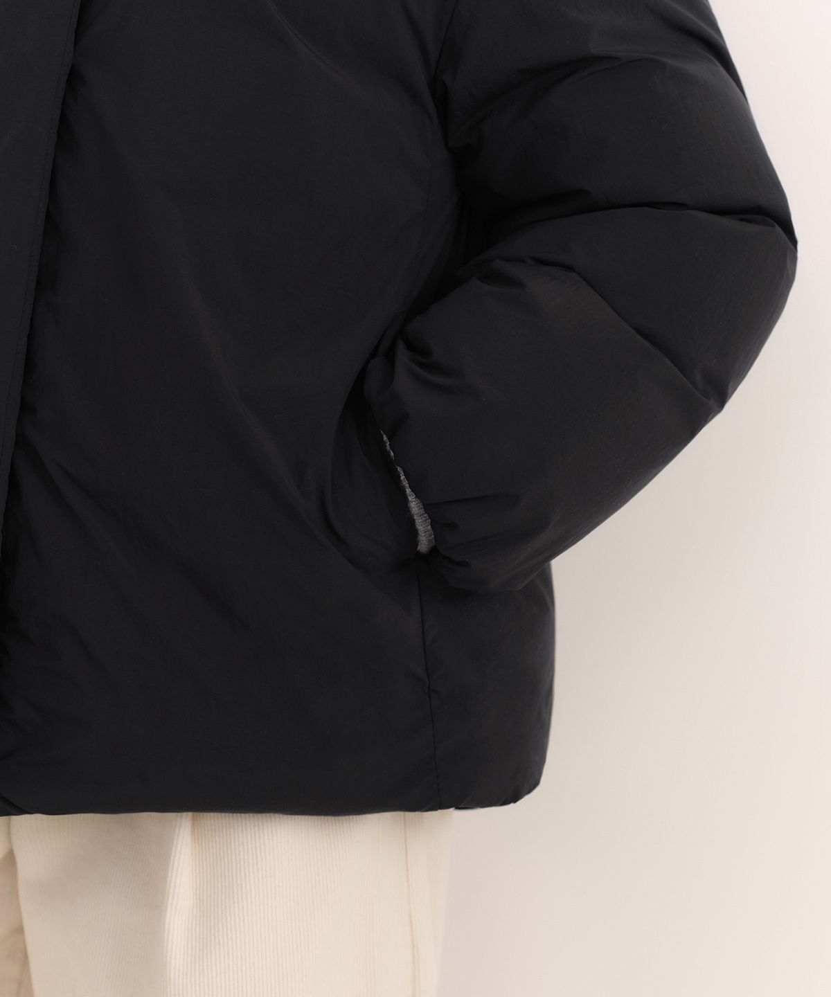 지퍼를 끝까지 올려 하이 넥 칼라가 목을 감싼 클로즈업 샷