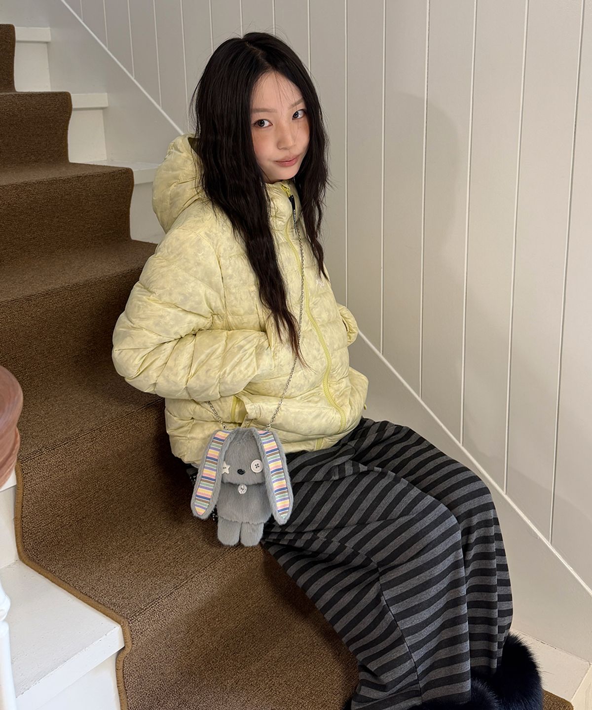 패딩을 입고 야외 공원 벤치에 앉아 여유를 즐기는 일상적인 모습