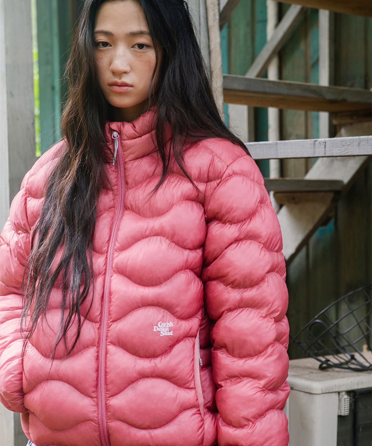 하이넥 지퍼를 끝까지 올려 목을 감싼 모습과 턱 끝까지 올라오는 카라의 디테일을 보여주는 옆모습