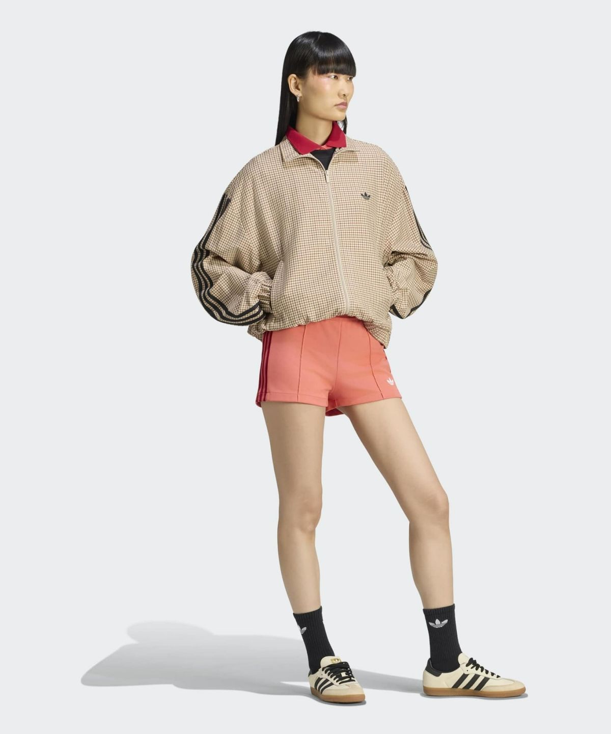 카페 조명 아래에서 체크 트랙탑의 오묘한 커피색 컬러감이 돋보이는 근접 촬영 컷