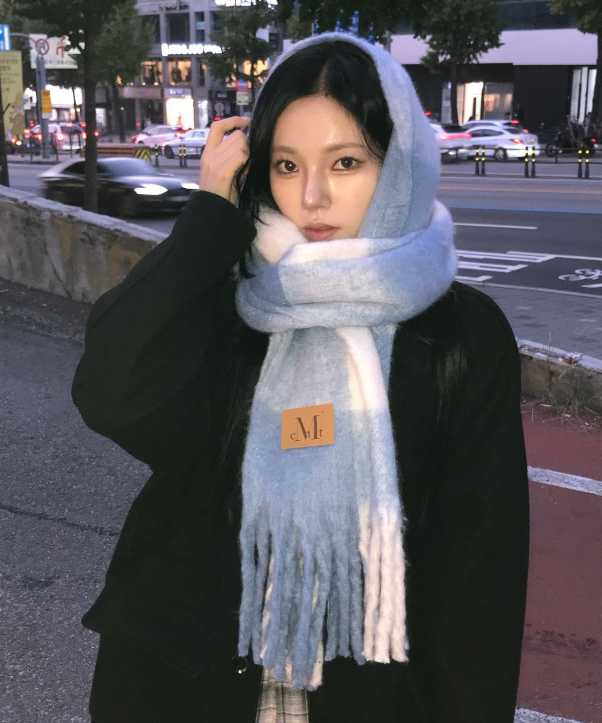 머플러의 부드러운 기모감이 느껴지는 근접 샷과 가죽 패치 로고 디테일
