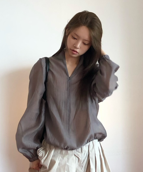 하프 집업의 지퍼를 반쯤 내리고 안의 이너와 레이어드된 넥 라인을 클로즈업한 사진