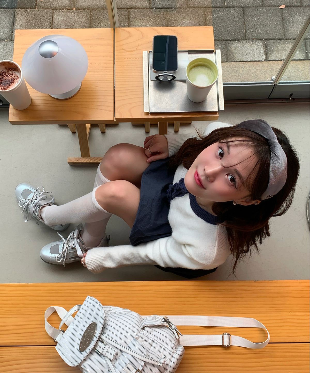 전신 거울 앞에서 스니커즈를 신고 옆모습을 비춰보며 굽 높이를 확인하는 장면