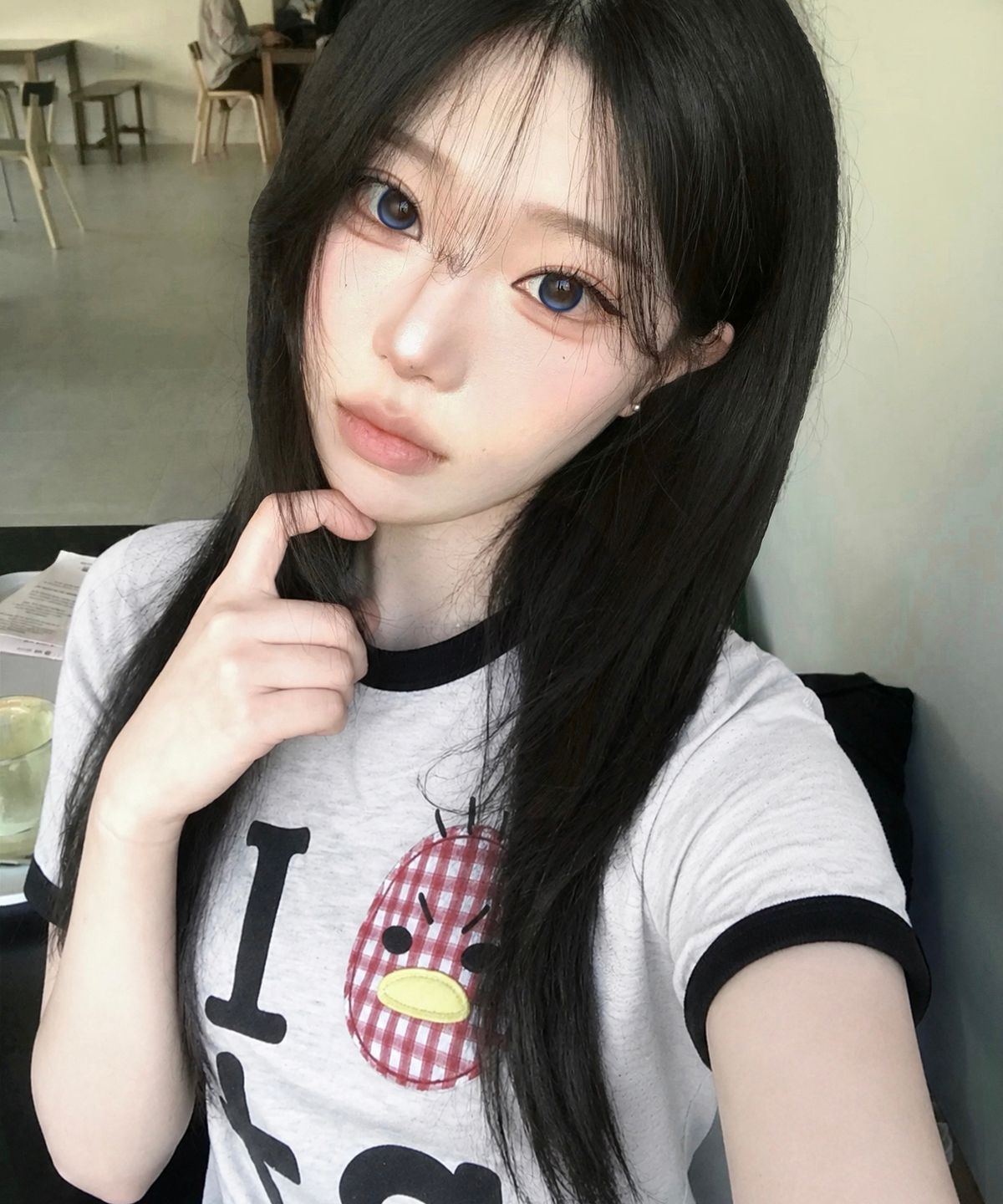 하이웨스트 데님 팬츠에 링거 티셔츠를 매치하고 거울 셀카를 찍는 모습, 골반 위로 떨어지는 핏 강조